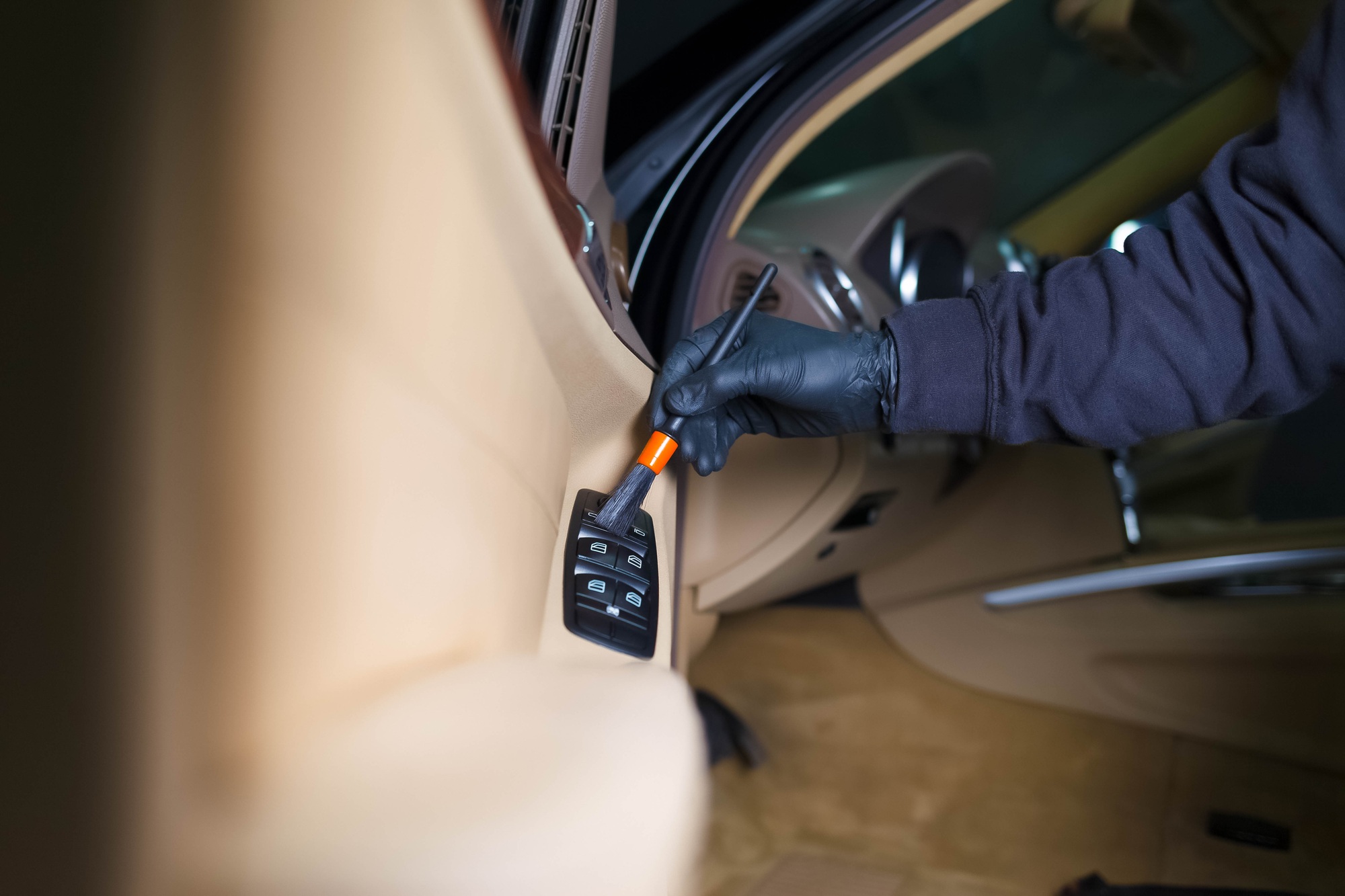 Detailing master cleans car interior with a brush